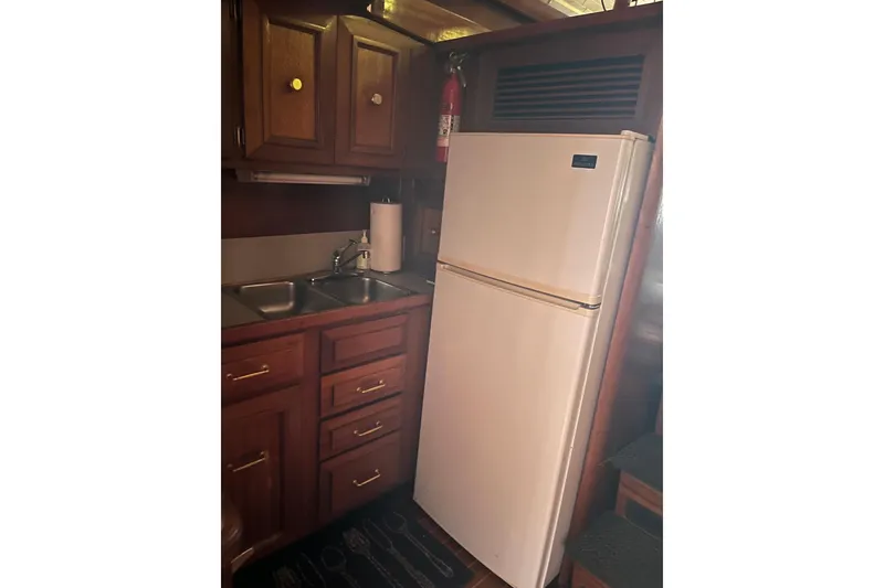 Slide: The Image of Interior cabin of a 1980 Egg Harbor 52 Convertible yacht, featuring wood paneling and portholes. - 28