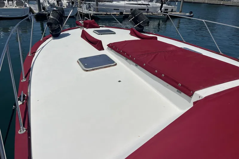 Slide: The Image of 1980 Golden Egg 48 Sport Fish boat deck with red covers, docked at marina. - 6