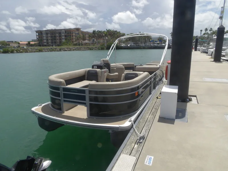 The Image of 2024 Harris Pontoon boat docked on a sunny day. - 0