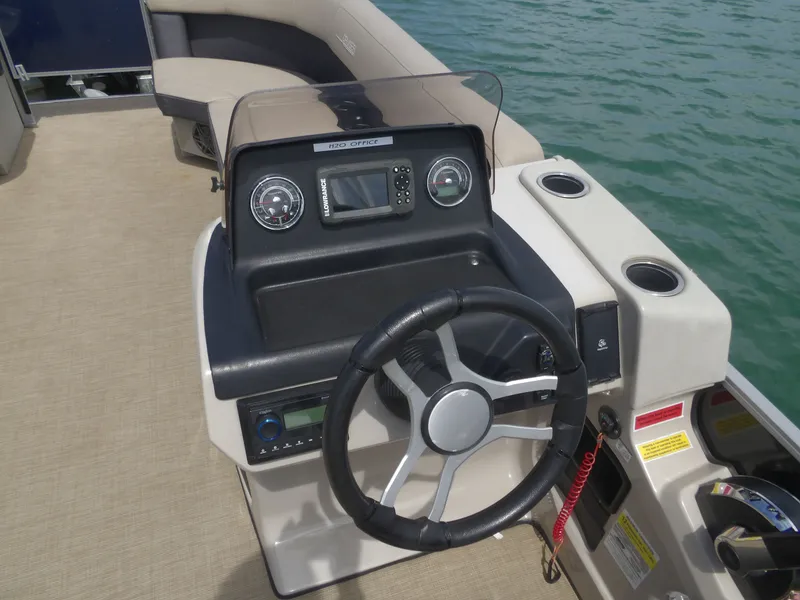 Slide: The Image of 2024 Harris Pontoon boat steering console on the water. - 10