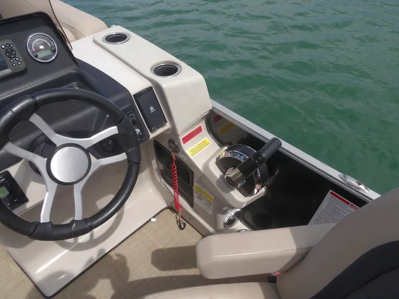 Slide: The Image of Steering console of a 2024 Harris Pontoon boat on the water. - 11