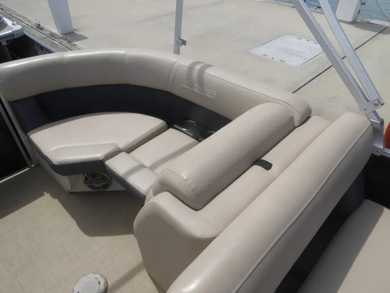 Slide: The Image of 2024 Harris Pontoon boat with beige leather seating at the dock. - 13