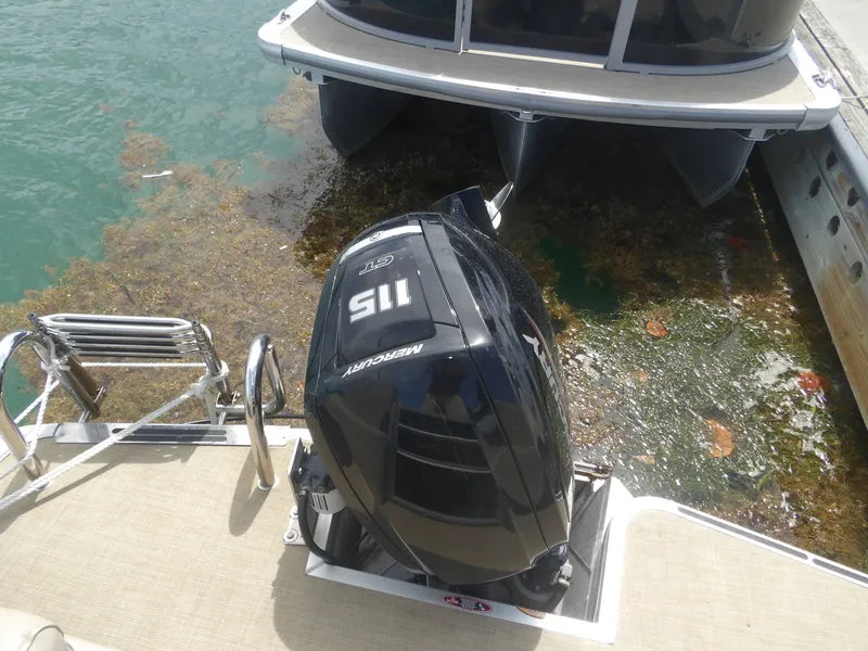 Slide: The Image of 2024 Harris Pontoon with Mercury 115 HP outboard motor at dock. - 16