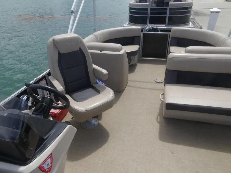 Slide: The Image of Interior of a 2024 Harris Pontoon boat with beige seating. - 8