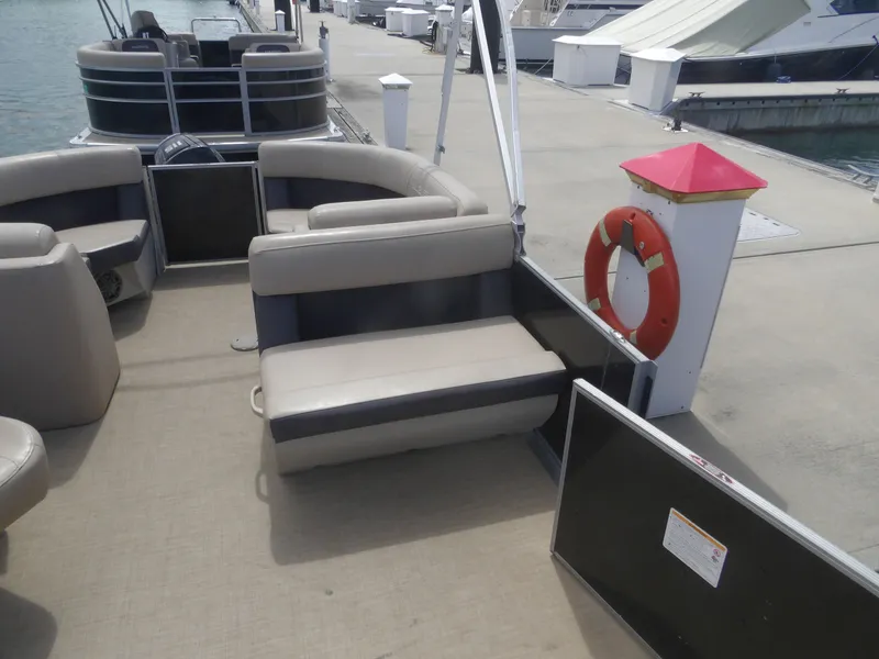 Slide: The Image of 2024 Harris Pontoon boat at dock with lifebuoy. - 9