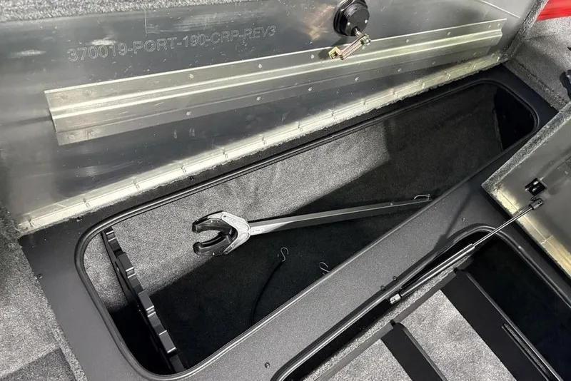 Slide: The Image of Open storage compartment in 2026 Tracker Pro Team 190 boat, featuring a tool inside. - 12