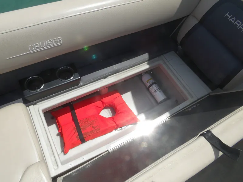 Slide: The Image of 2024 Harris Pontoon seat storage with life jacket and fire extinguisher. - 10