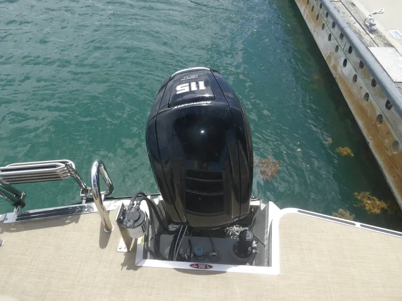 Slide: The Image of 2024 Harris Pontoon with outboard motor at dock. - 17