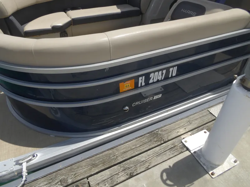 Slide: The Image of 2024 Harris Pontoon Cruiser 230 at dock with Florida registration. - 2