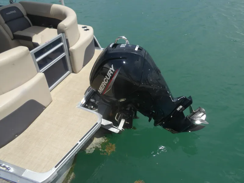 Slide: The Image of 2024 Harris Pontoon with Mercury outboard motor on calm water. - 20