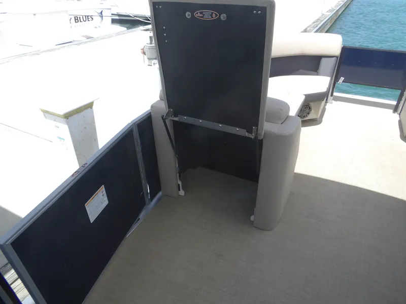 Slide: The Image of 2024 Harris Pontoon with foldable seat by the water. - 27