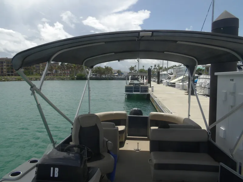 Slide: The Image of 2024 Harris Pontoon boat docked at marina, sunny day. - 4