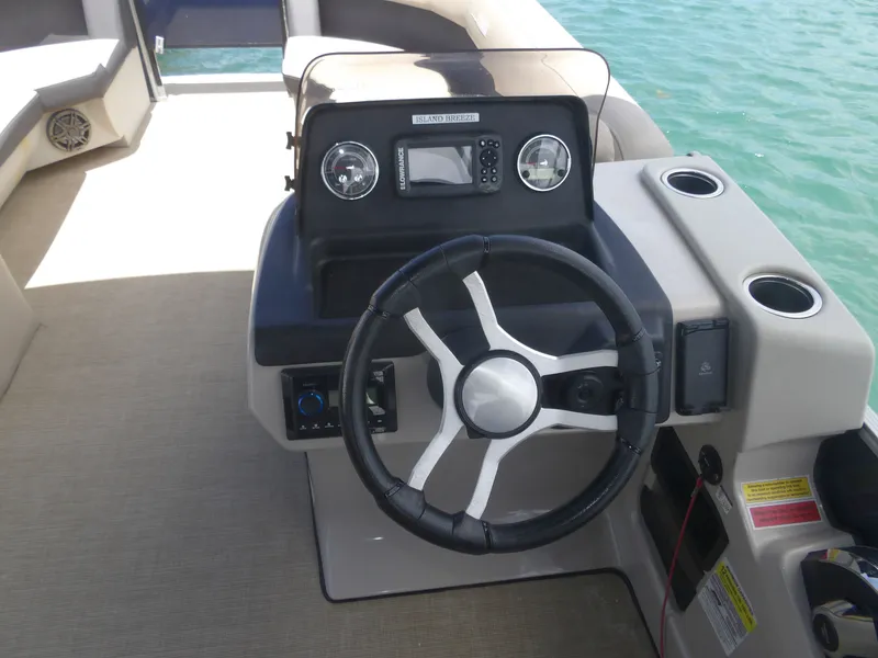 Slide: The Image of 2024 Harris Pontoon boat steering console with wheel and dashboard. - 7