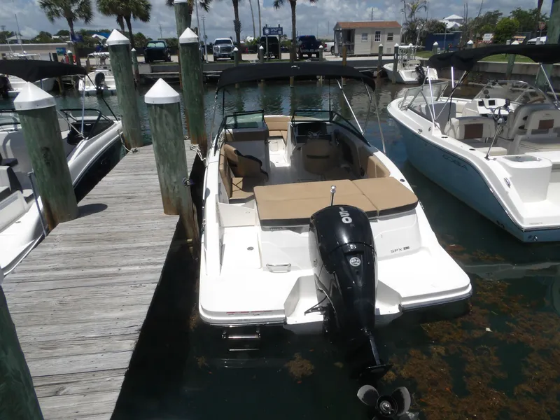 Slide: The Image of 2024 Sea Ray SPX 230 boat docked on a sunny day. - 2