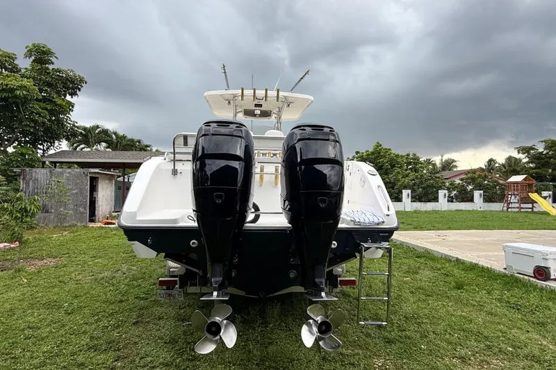 Slide: The Image of 2007 Century 3200 Center Console boat with dual outboard motors, parked on grass. - 1