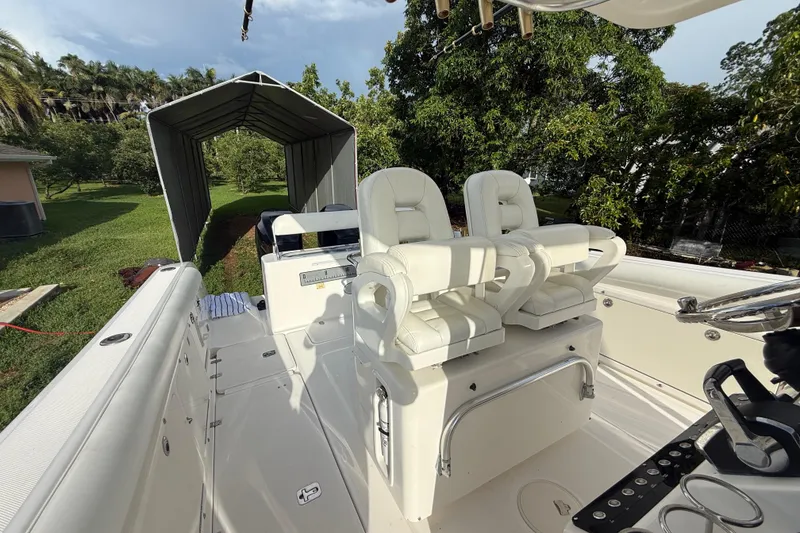 Slide: The Image of 2007 Century 3200 Center Console boat with white seating and lush green surroundings. - 14
