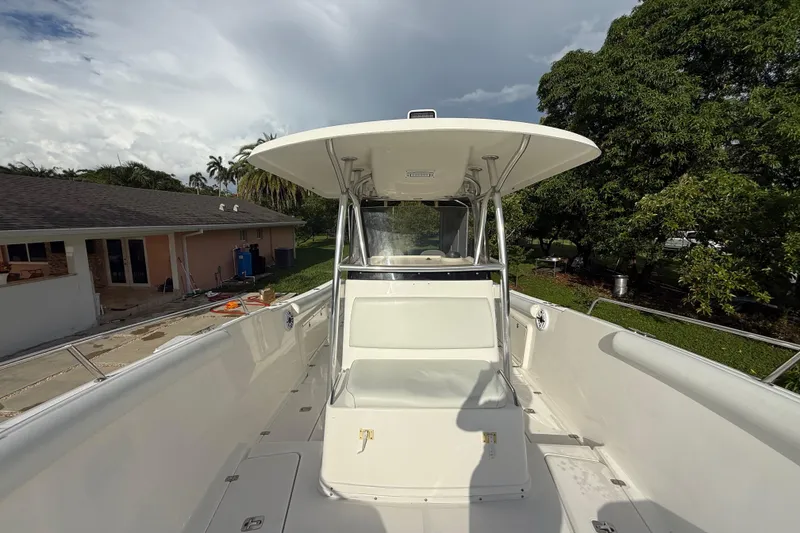 Slide: The Image of 2007 Century 3200 Center Console boat with T-top, docked near a house and trees. - 21