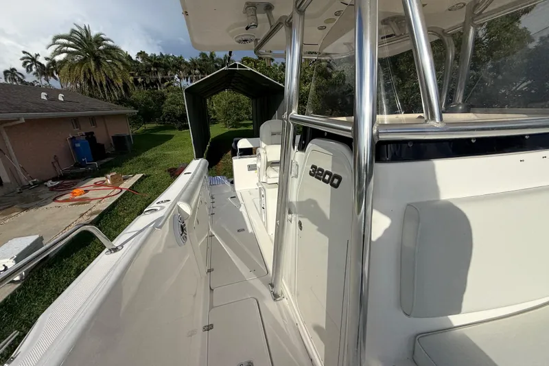 Slide: The Image of 2007 Century 3200 Center Console boat docked near a house with palm trees. - 23