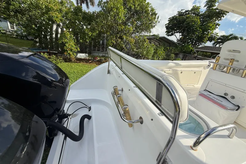 Slide: The Image of 2007 Century 3200 Center Console boat with railing and engine, surrounded by greenery. - 25