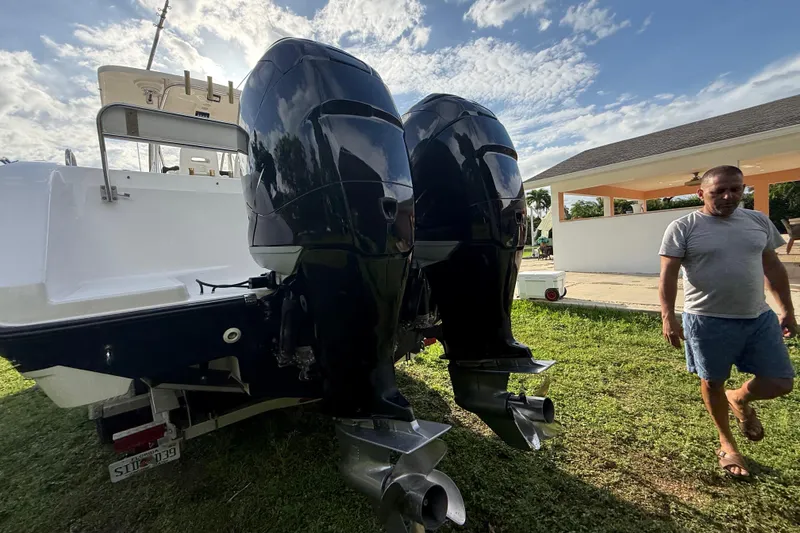 Slide: The Image of 2007 Century 3200 Center Console boat with dual outboard motors on grass. - 27