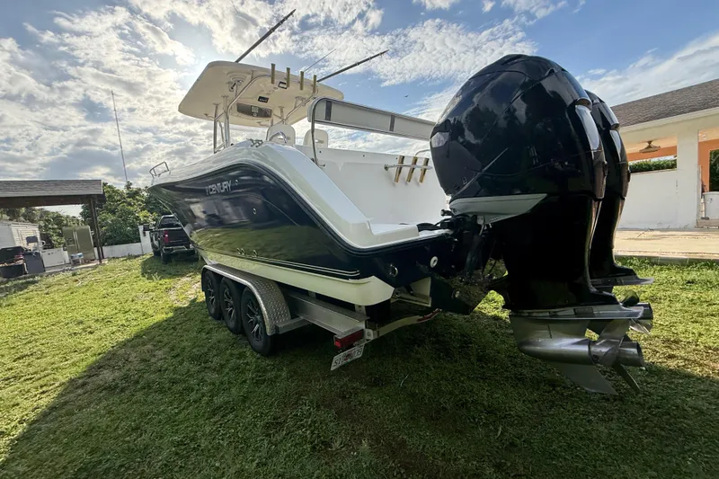 Slide: The Image of 2007 Century 3200 Center Console boat on trailer, dual outboard motors, parked on grass. - 28