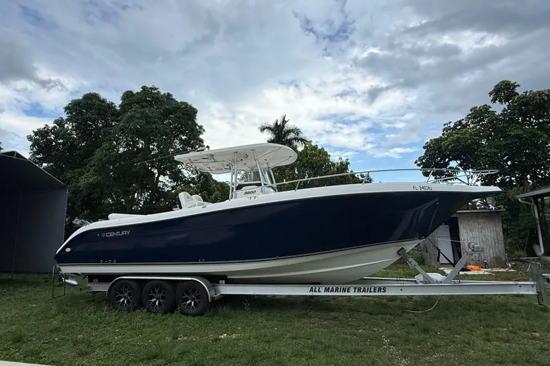 Slide: The Image of 2007 Century 3200 Center Console boat on trailer, parked outdoors under cloudy sky. - 3