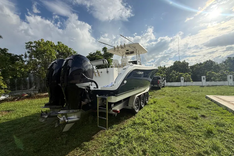 Slide: The Image of 2007 Century 3200 Center Console boat on trailer, parked on grassy area under blue sky. - 4