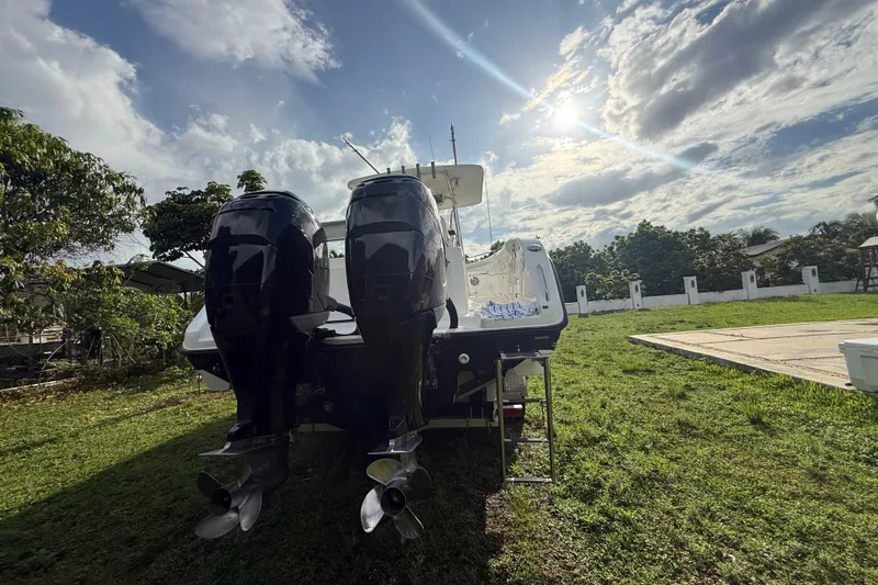 Slide: The Image of 2007 Century 3200 Center Console boat with dual engines on grassy yard under sunny sky. - 5