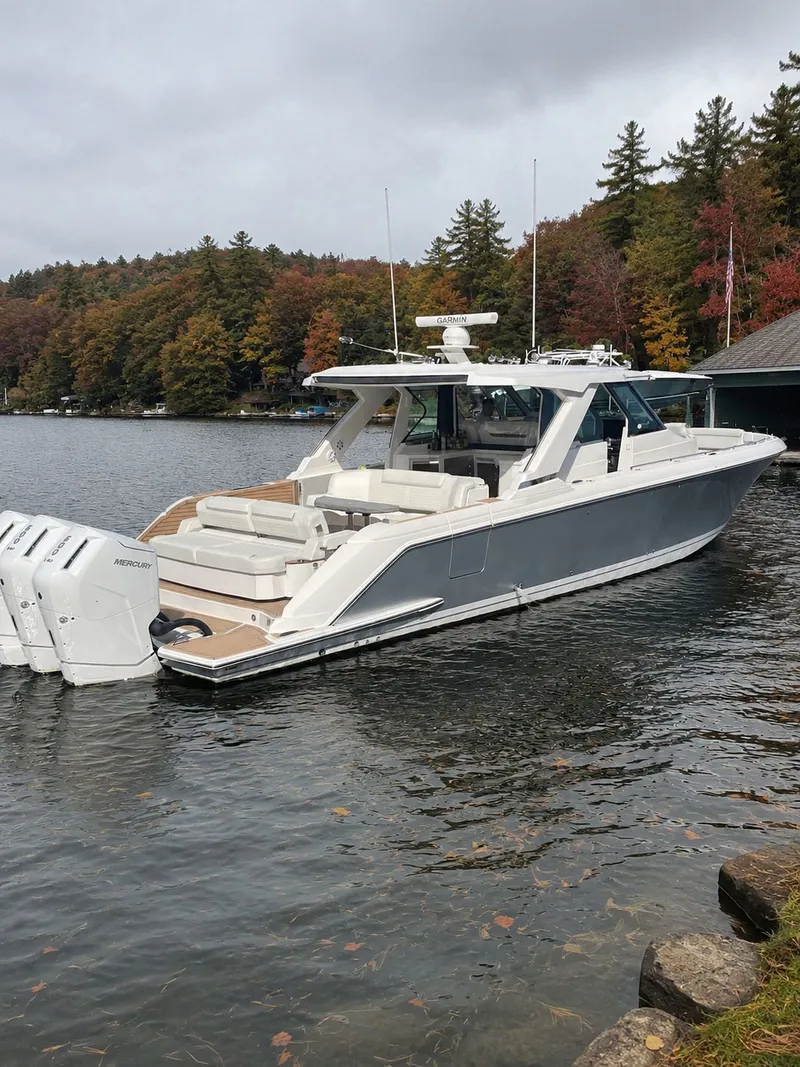 Slide: The Image of 2023 Tiara Yachts 48 LS on a serene lake with autumn trees. - 1