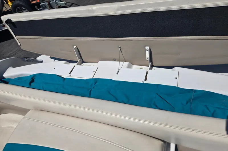 Slide: The Image of 1996 Four Winns 200 Horizon boat interior with open storage compartment and blue cover. - 10