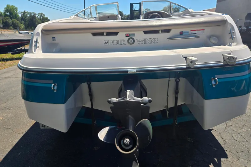 Slide: The Image of 1996 Four Winns 200 Horizon boat, rear view with visible propeller and branding. - 2