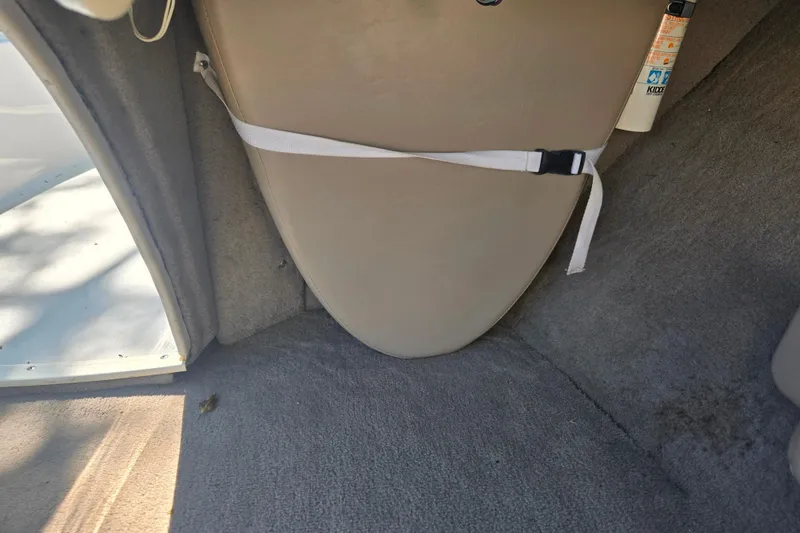 Slide: The Image of Interior of a 1996 Four Winns 200 Horizon boat, featuring carpeted flooring and storage compartment. - 5