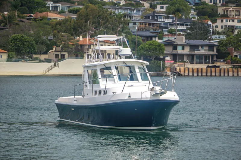Slide: The Image of 2006 Albin 28 Tournament Express boat cruising near waterfront homes. - 4