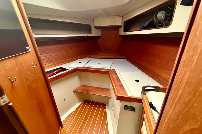 Slide: The Image of 1983 C&C 34 sailboat interior with wooden cabinetry and storage compartments. - 10