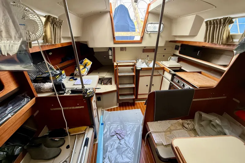 Slide: The Image of Interior of a 1983 C&C 34 sailboat, featuring a compact kitchen and cozy living space. - 11