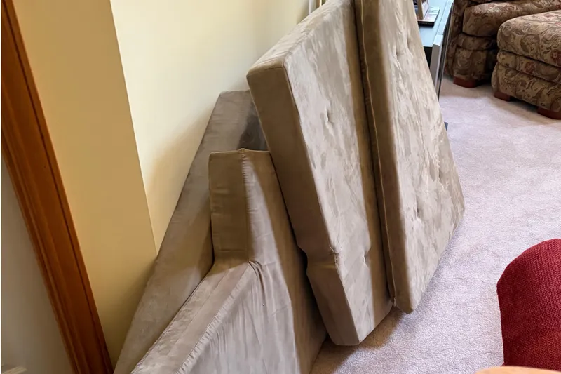 Slide: The Image of Cushions from a 1983 C&C 34 sailboat, stacked indoors on a carpeted floor. - 15