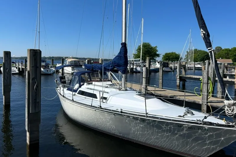 Slide: The Image of 1983 C&C 34 sailboat docked at a marina on a sunny day. - 17