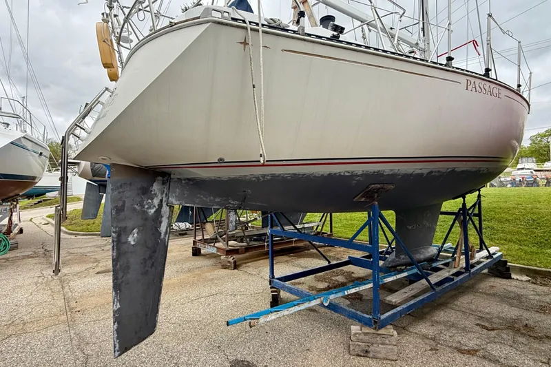 Slide: The Image of 1983 C&C 34 sailboat on a stand, showing hull and keel in a boatyard. - 5