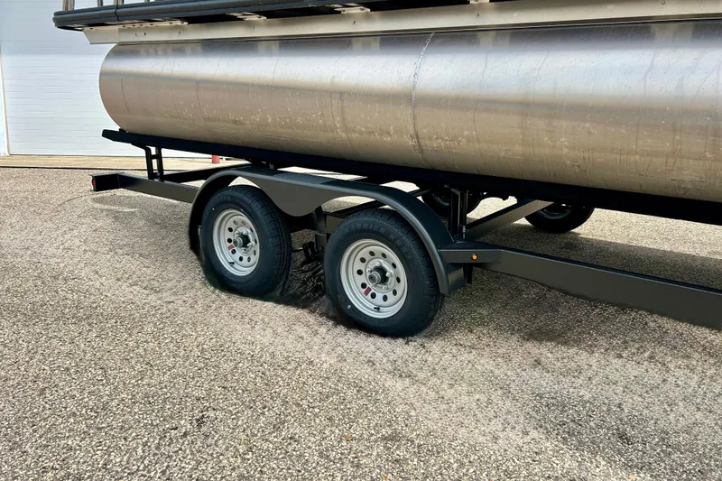 Slide: The Image of 2022 Starcraft CX 21 C pontoon boat on a trailer, showcasing dual wheels. - 10