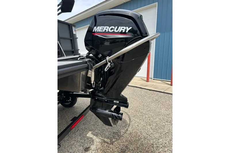 Slide: The Image of 2022 Starcraft CX 21 C boat with Mercury outboard motor, parked near a blue building. - 22