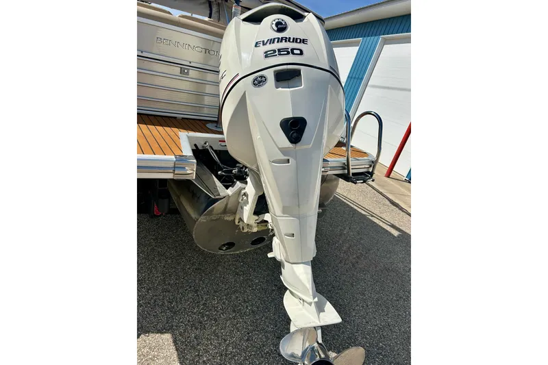 Slide: The Image of 2012 Bennington 2250RCL with Evinrude 250 outboard motor, parked on pavement. - 14