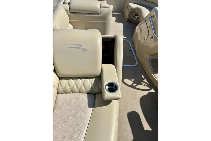 Slide: The Image of Luxurious interior of a 2012 Bennington 2250RCL pontoon boat with beige seating and cup holder. - 31