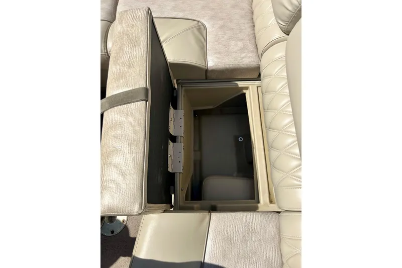 Slide: The Image of Open storage compartment in 2012 Bennington 2250RCL boat seat with beige upholstery. - 39