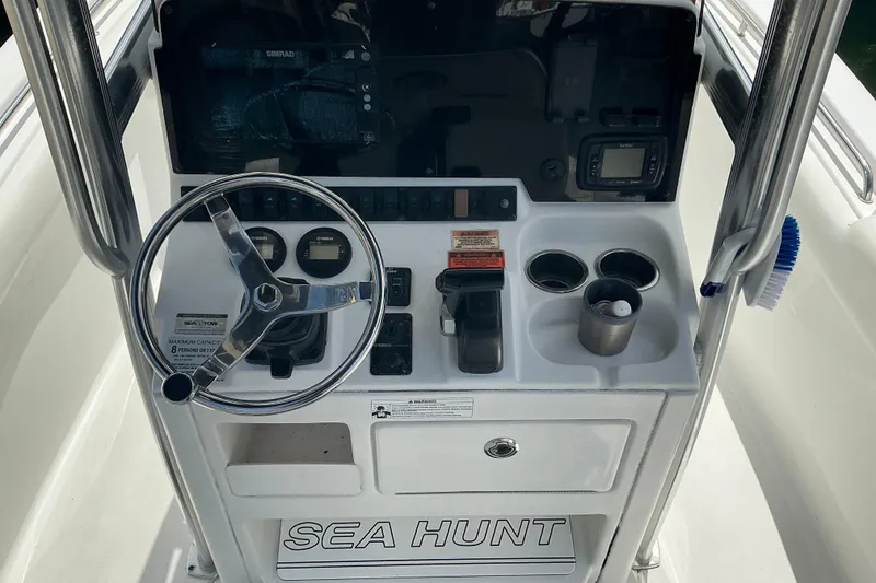 Slide: The Image of Steering console of a 2017 Seahunt 225 Triton boat with controls and cup holders. - 10