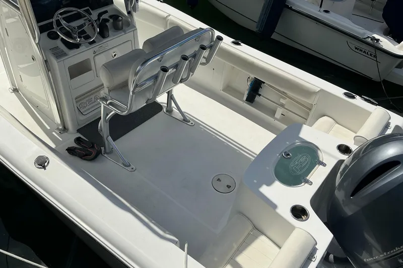 Slide: The Image of 2017 Seahunt 225 Triton boat interior with seating, steering console, and fishing rod holders. - 6