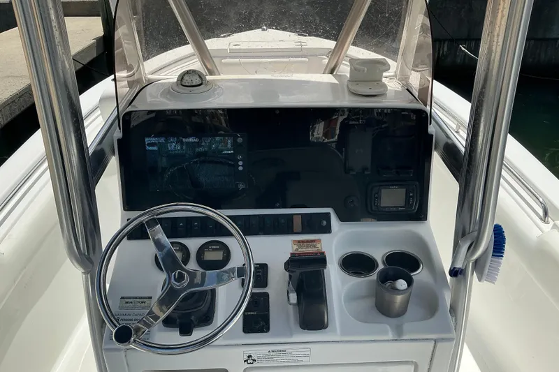Slide: The Image of 2017 Seahunt 225 Triton boat console with steering wheel, gauges, and cup holders. - 9