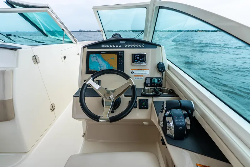 Slide: The Image of 2017 Boston Whaler 320 Vantage helm with navigation system, steering wheel, and throttle controls. - 22