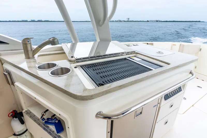 Slide: The Image of 2017 Boston Whaler 320 Vantage boat with outdoor kitchen and grill, ocean in background. - 24