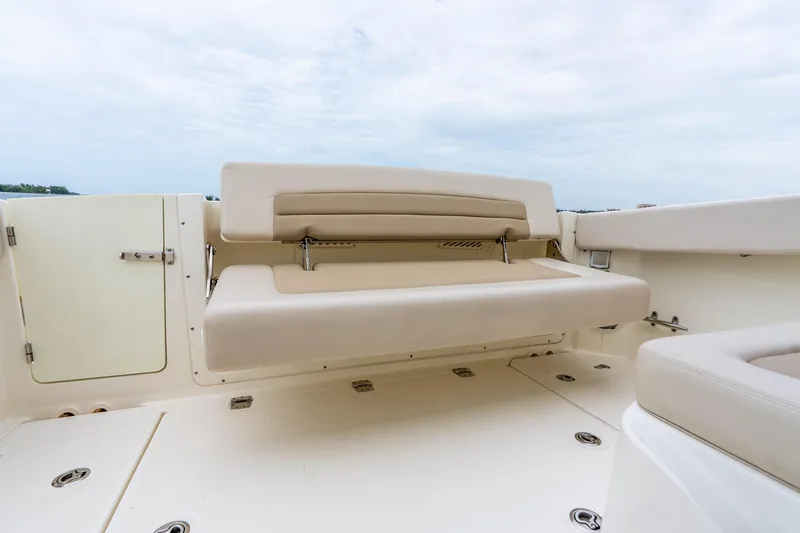 Slide: The Image of 2017 Boston Whaler 320 Vantage boat interior with beige seating and storage compartment. - 34