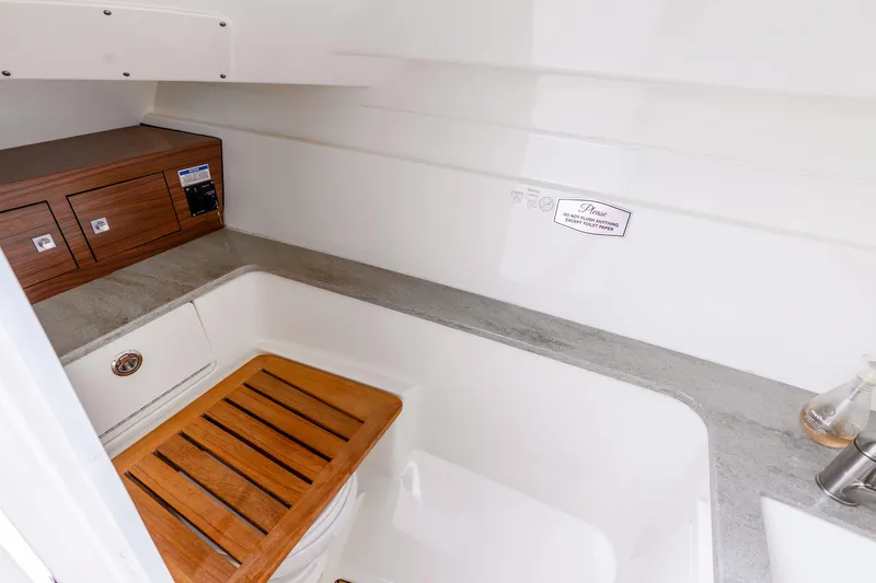 Slide: The Image of Interior of 2017 Boston Whaler 320 Vantage boat, featuring a compact bathroom area. - 45